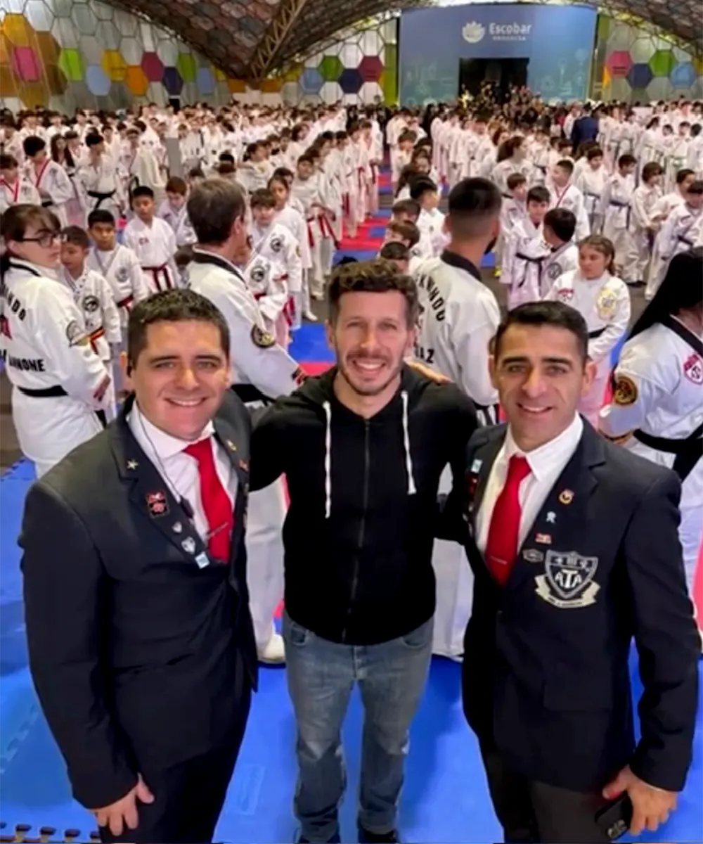 Autoridades del evento de taekwondo y filas de alumnos formados a sus espaldas