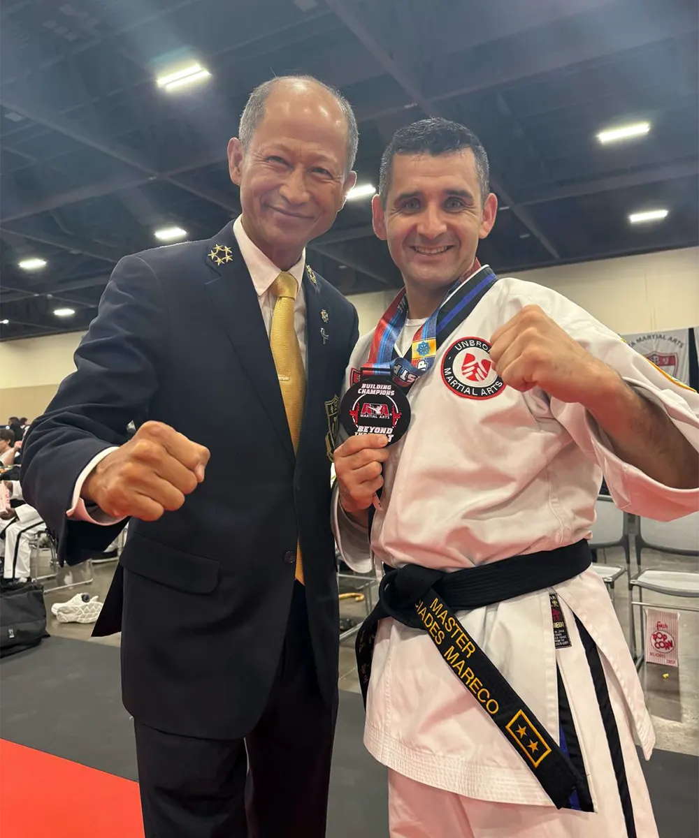 Mareco sonriente junto al gran master In-ho Lee, máxima autoridad del taekwondo.
