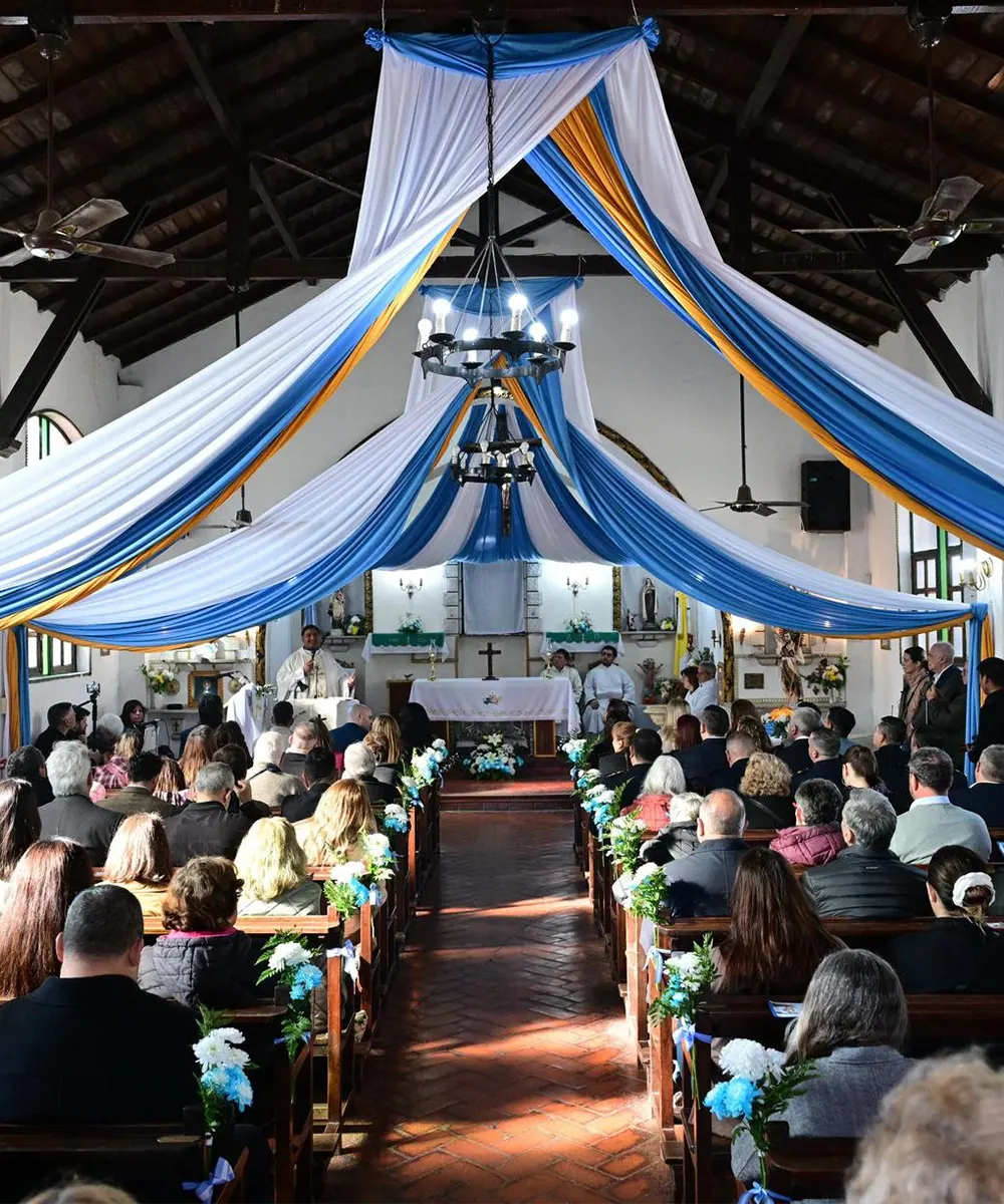 Tradicional Tedeum en la parroquia San Juan Bautista, adornada con banderas.