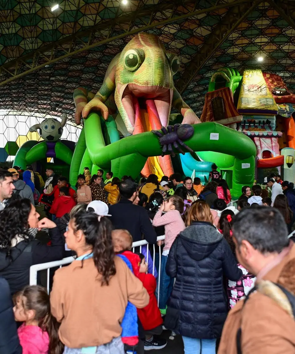 Niños y familias jugando en inflables gigantes durante las vacaciones de invierno.