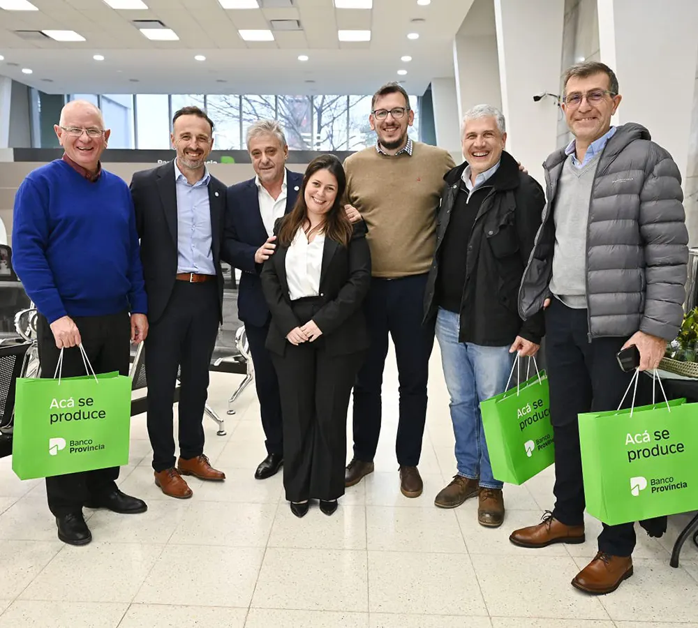 Juan Cuattromo junto a empleados del Banco Provincia en el interior de la sucursal de Escobar