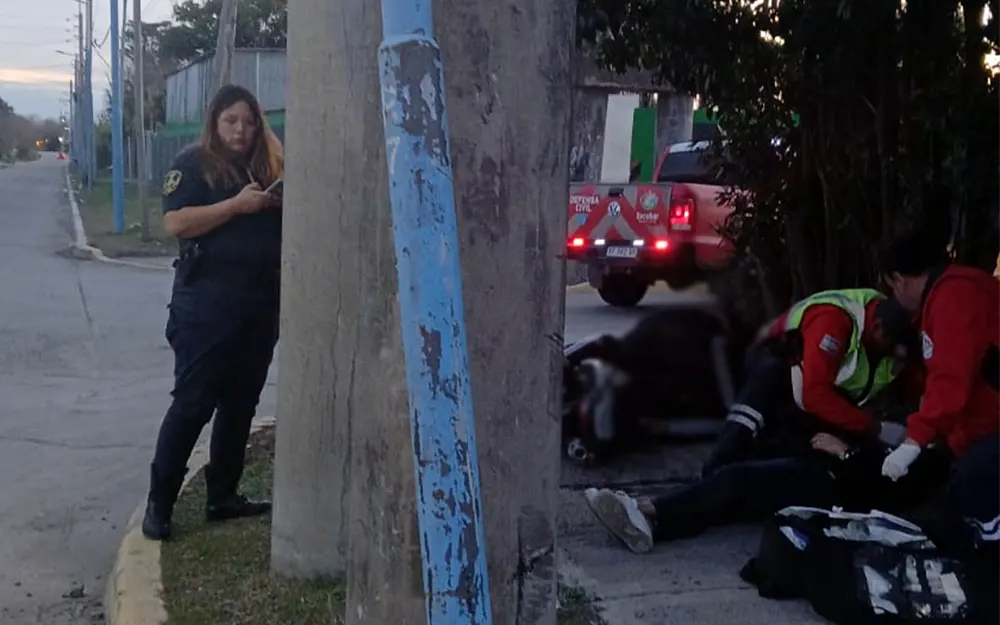 Personal de Defensa Civil y paramédicos asistiendo a las víctimas, donde un motociclista murió tras impactar contra un poste de luz.