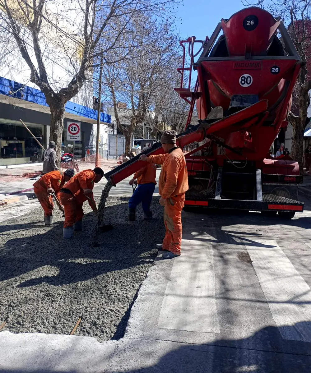 Obreros desparraman el material sobre el tramo a reparar