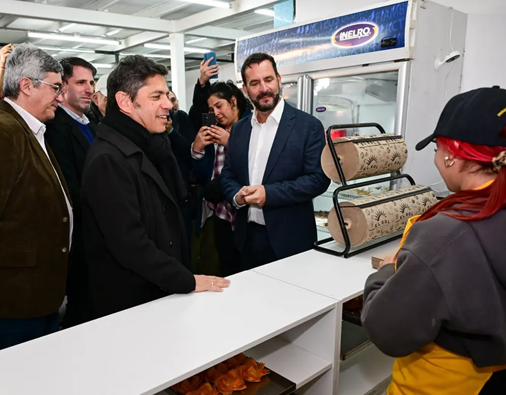 Axel Kicillof y Ariel Sujarchuk conversan con una vendedora en su puesto del Mercado Fijo Bonaerense.