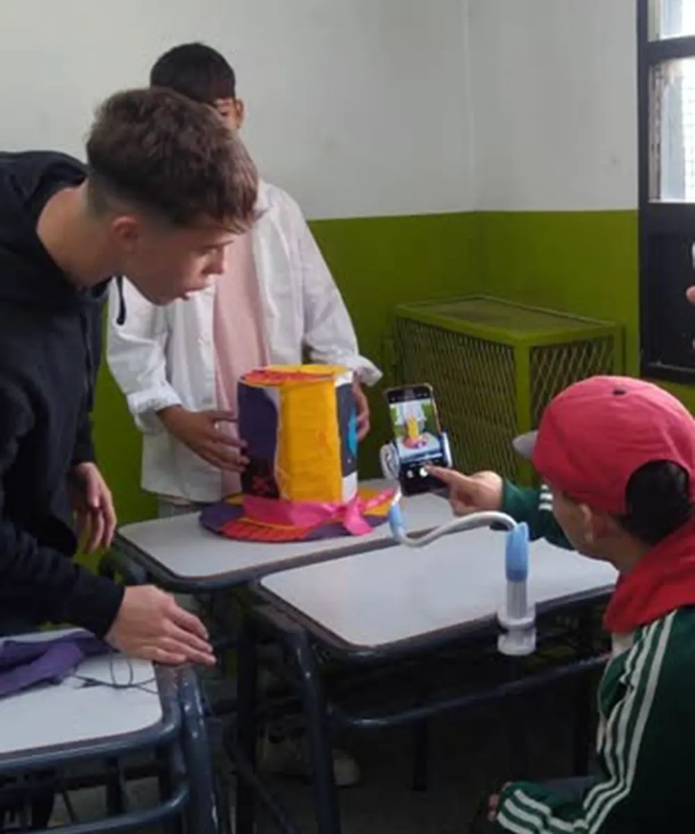 Alumnos de la Escuela Secundaria tomando fotos de uno de las partes del proyecto inspirado en la obra de Alicia el País de las Maravillas.