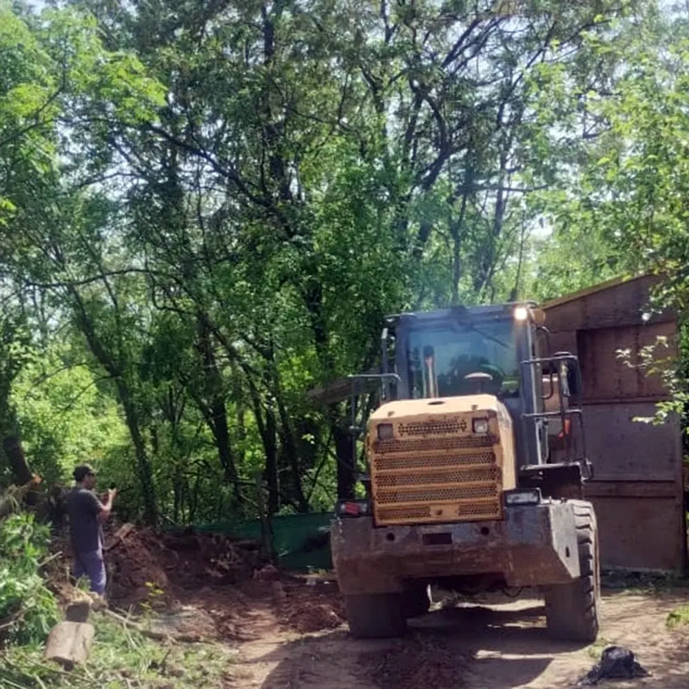 Una máquina con pala mecánica realiza la limpieza del predio.