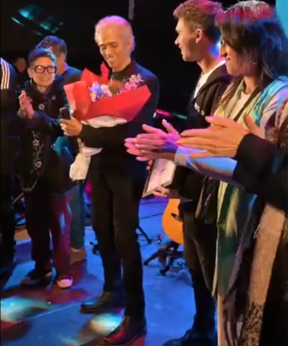 Jairo recibiendo un ramo de flores en una presentación en Loma Verde en 2023