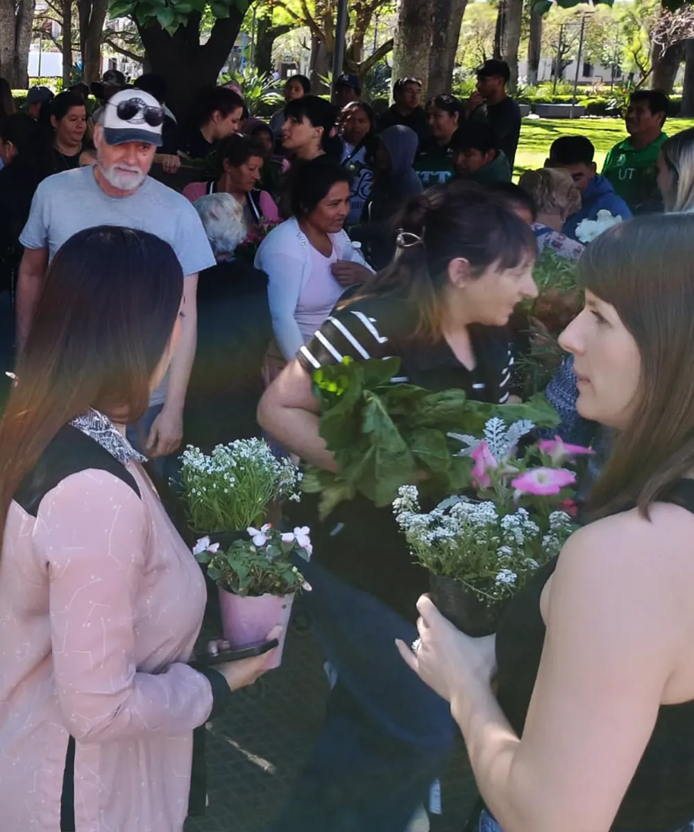Vecinos con las plantas ornamentales que les regalaron los productores.