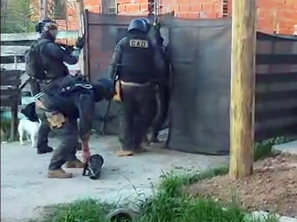 Agentes policiales ingresan a una vivienda en Garín