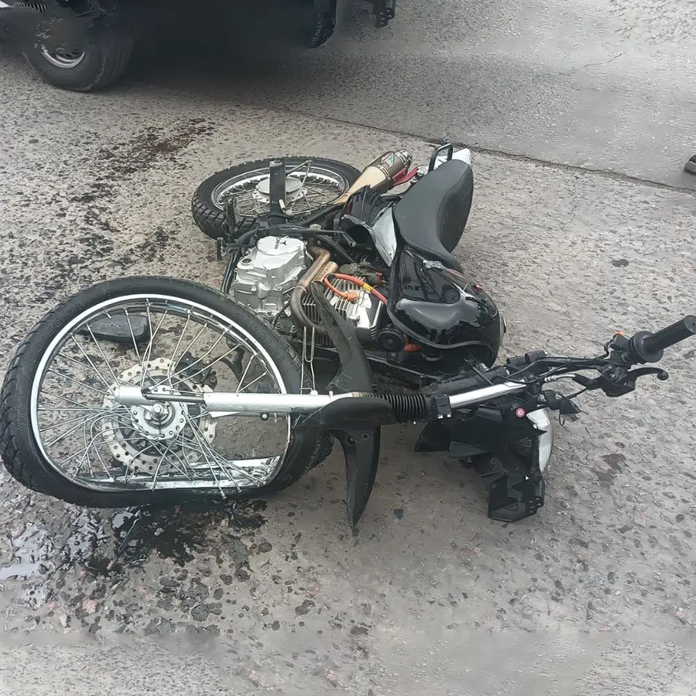 Tras el choque, la motocicleta sufrió serios daños la rueda delantera torcida, el manubrio roto y varias piezas esparcidas sobre el pavimento.