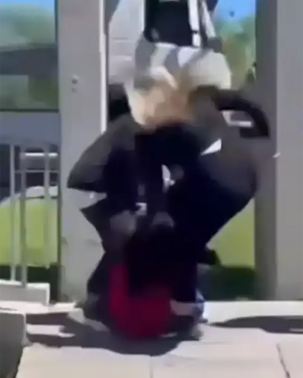 Una mujer patea a una de las alumnas que está en el piso