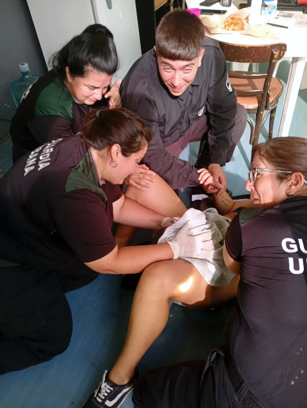 Los agentes municpales brindando ayuda a la joven durante el parto.