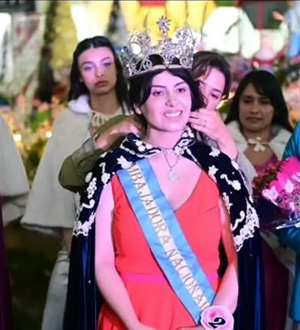 La primera embajadora recibiendo la capa y corona durante la ceremonia.