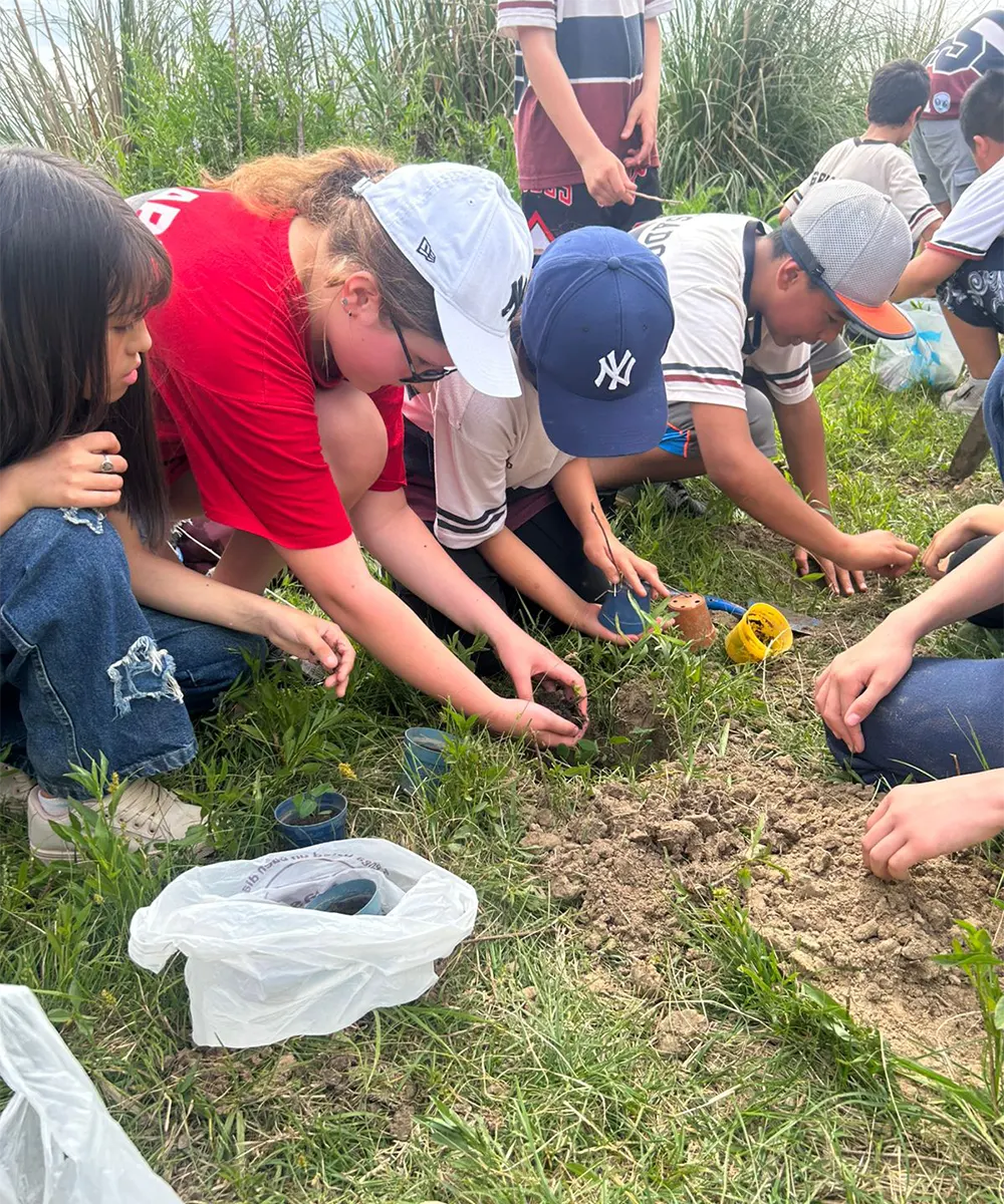 Estudiantes plantan árboles nativos.