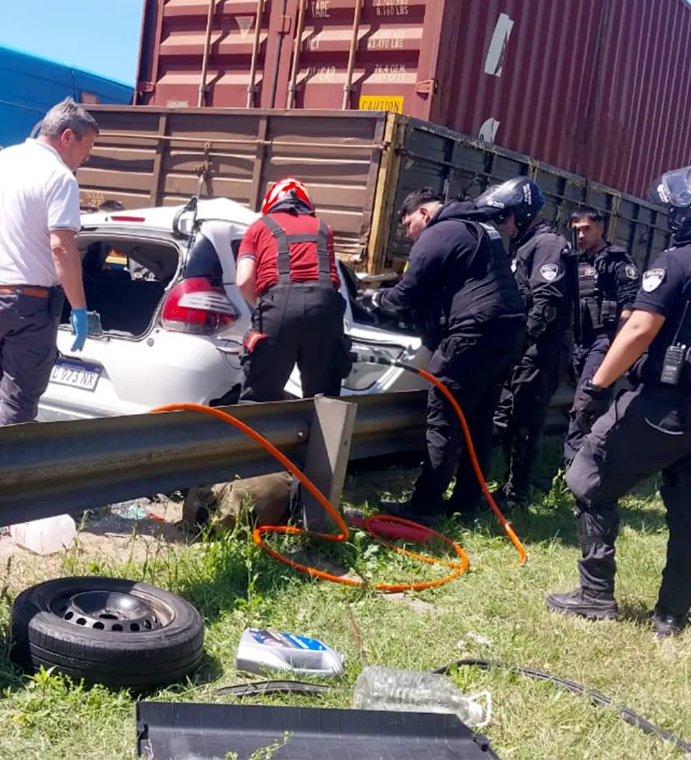 Bomberos rescatan a los ocupantes del auto incrustado bajo el camión