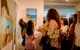 Gente observando la exposición de cuadros en el HCD