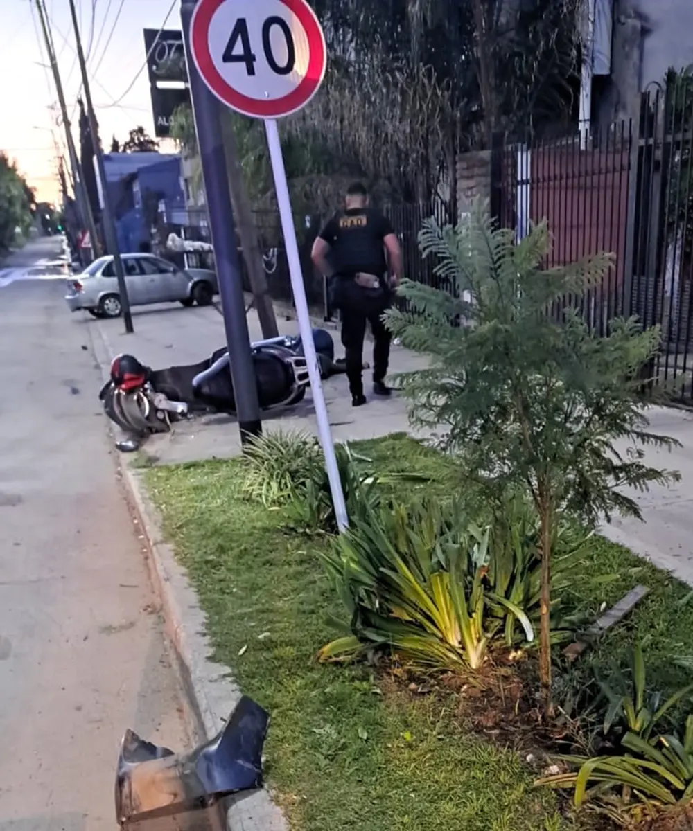 la moto en el piso tras chocar contra el poste