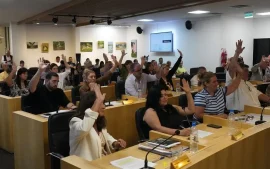 Concejales levantan la mano para marcar su voto
