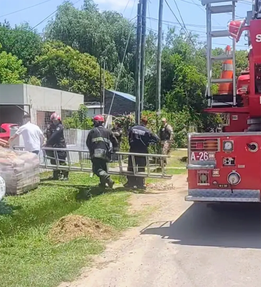 Bomberos ingresan a la casa con una escalera para rescatar al hombre del pozo