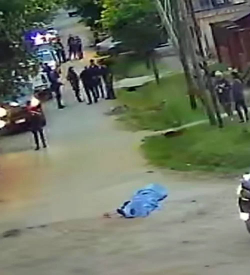 patrulleros y polic&iacute;as en la calle, con el cuerpo de la v&iacute;ctima tapado