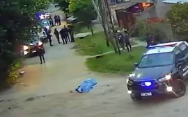 patrulleros y policías en la calle, con el cuerpo de la víctima tapado