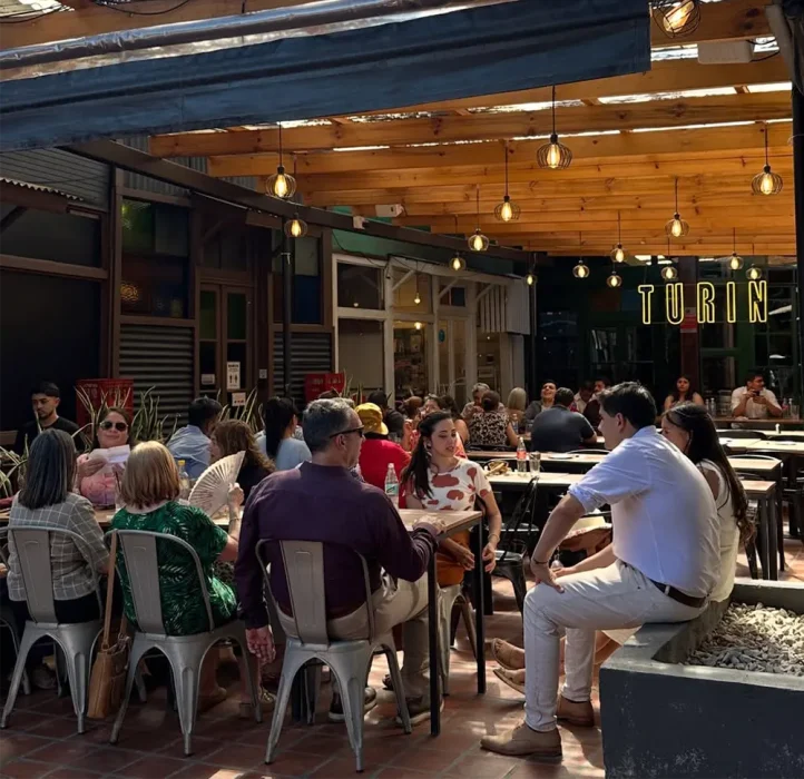 Gente comiendo en el patio de Turín Pizza & Coffee