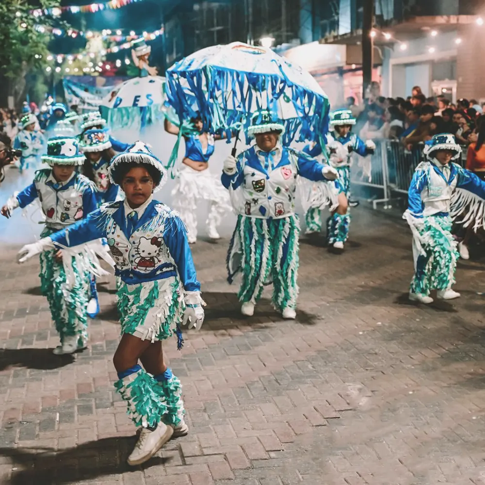 Una agrupaci&oacute;n de murga bailando por las calles celebrando el Carnaval de la Flor.