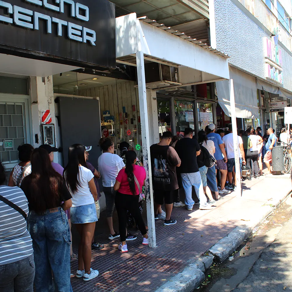 Gente haciendo la cola para hacer las compras escolares