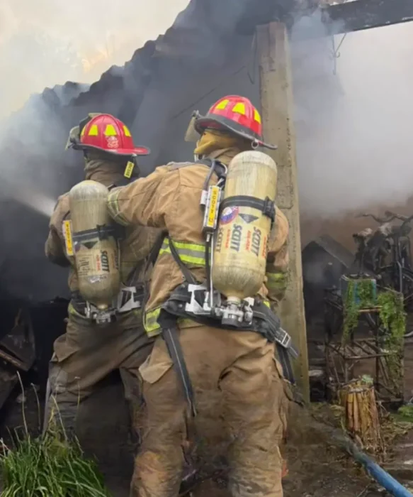 Bomberos Voluntarios socorriendo el incendio.