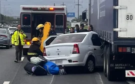 auto incrustado bajo un camión