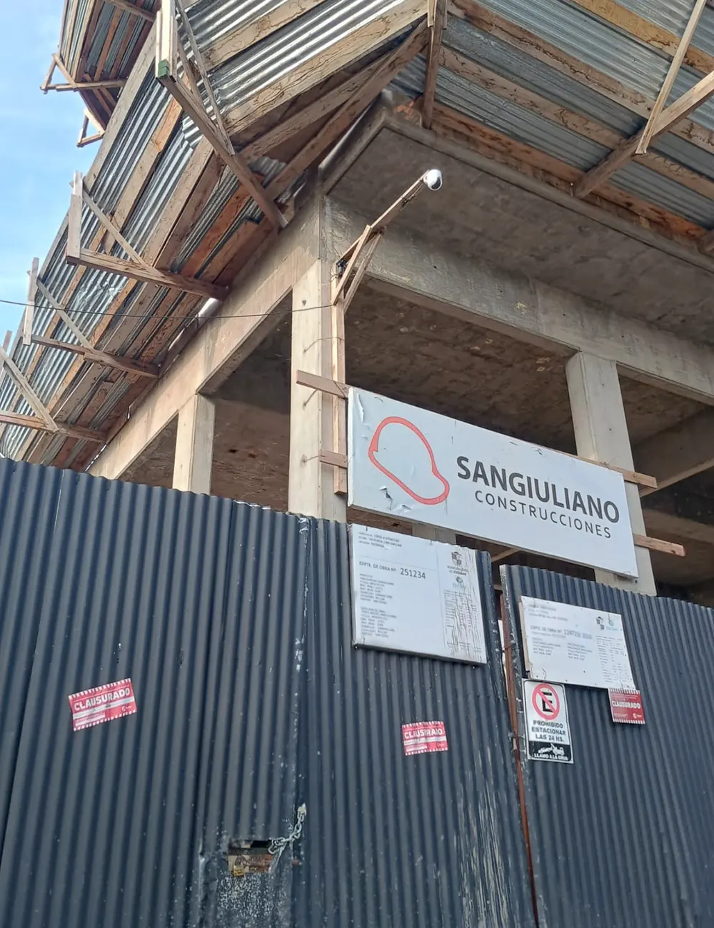 Portón de acceso del edificio con el cartel de clausura.