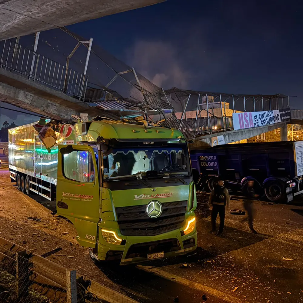un cami&oacute;n de la empresa V&iacute;a Cargo atrapado bajo los restos del puente.
