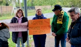 Dos vecinas de El Cazador sostienen carteles con reclamos