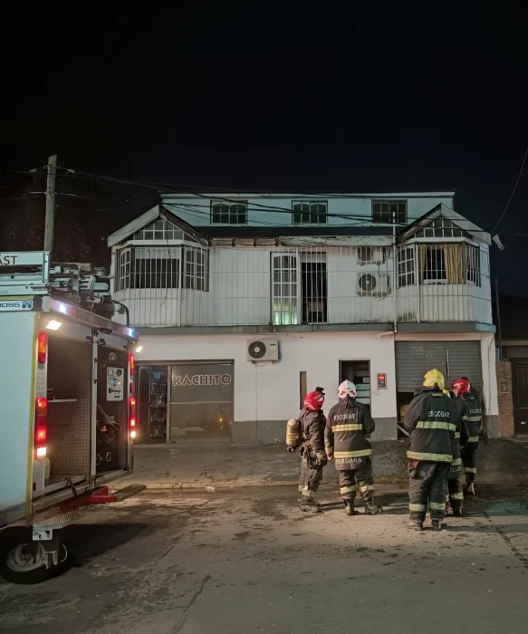 Bomberos en el frontis de la distribuidora de golosinas después de apagar el incendio.