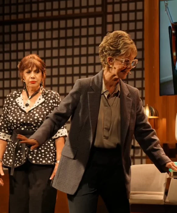En escena, dos actrices; una la mira, la otra le da la espalda.  