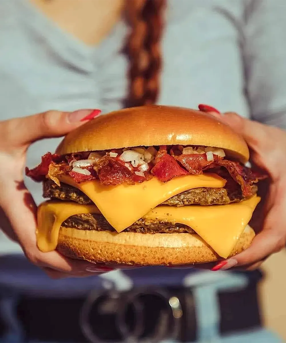 Manos que sostienen una hamburguesa