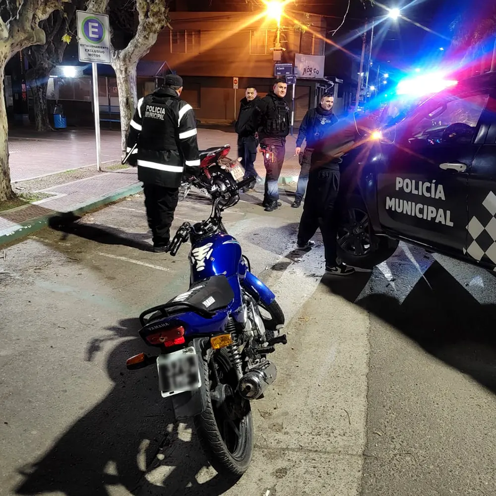 Efectivos policiales deteniendo a un joven motocilista.