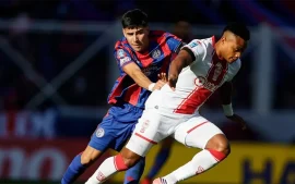 Nicolás Blanco marca a un jugador de Huracán