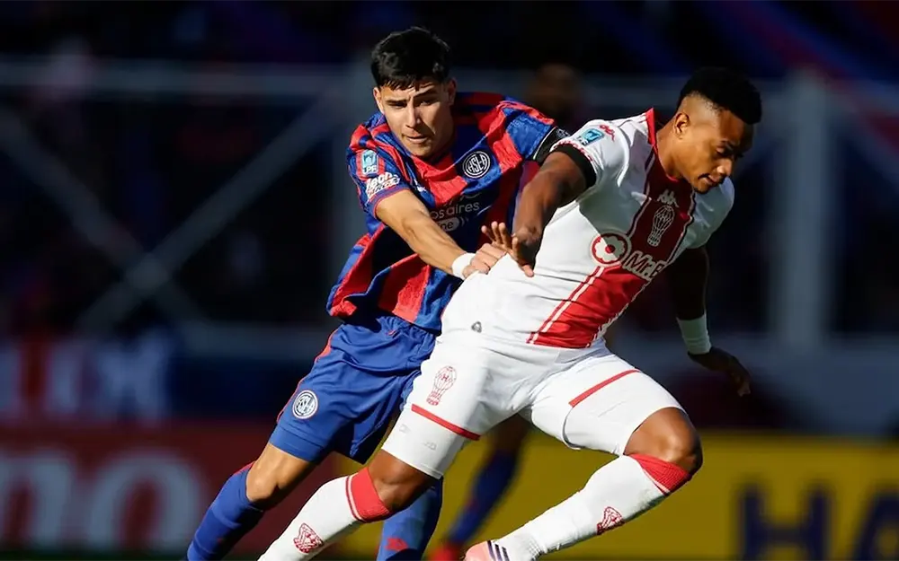 Nicolás Blanco marca a un jugador de Huracán