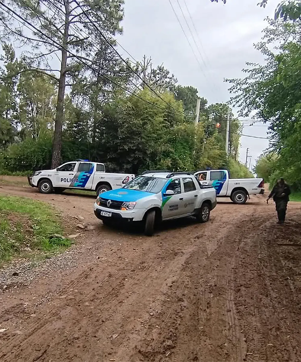 Vehículos policiales sobre la calle del predio del barrio El Cazador.