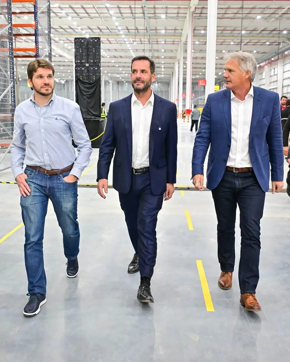 Adri&aacute;n Ecker, Ariel Suajrchuk y Paul Hogg recorren la planta de Mercado Libre en Escobar