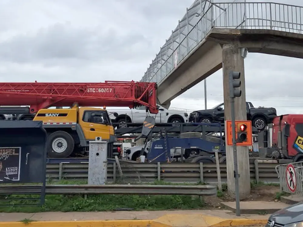 Un camión que transportaba una grúa, atorado en la pasarela del kilómetro 50.